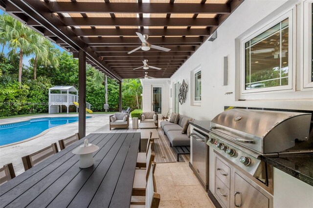 view of patio with area for grilling, outdoor lounge area, and an outdoor kitchen