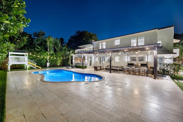 pool at twilight with a bar and a patio area