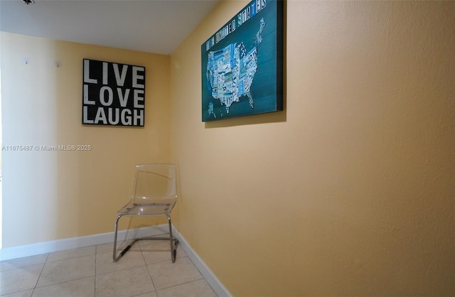 corridor featuring light tile patterned floors and baseboards