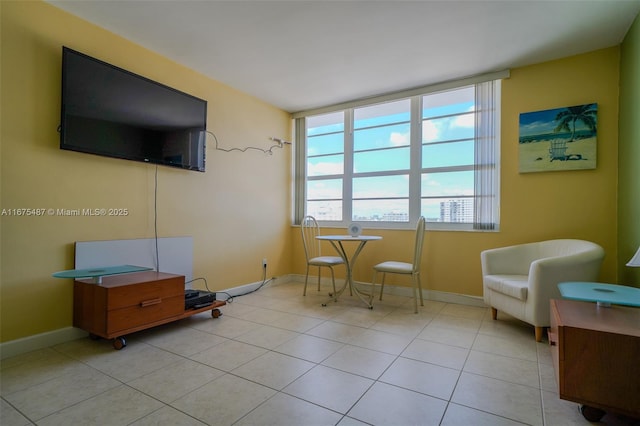 living area featuring light tile patterned flooring and baseboards