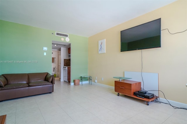 living room with light tile patterned floors, baseboards, and visible vents