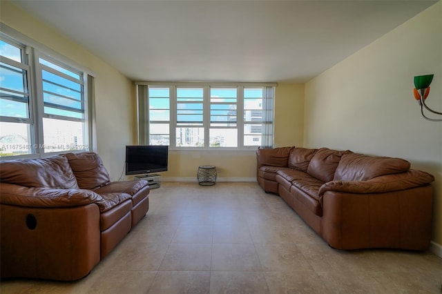 living area with light tile patterned floors, plenty of natural light, and baseboards