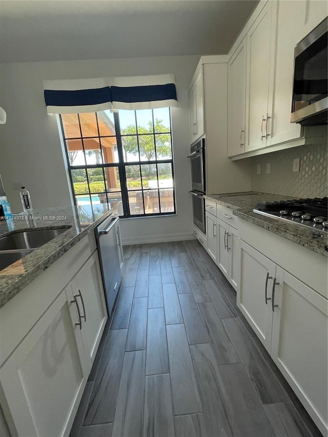 kitchen featuring light stone countertops, appliances with stainless steel finishes, and white cabinetry