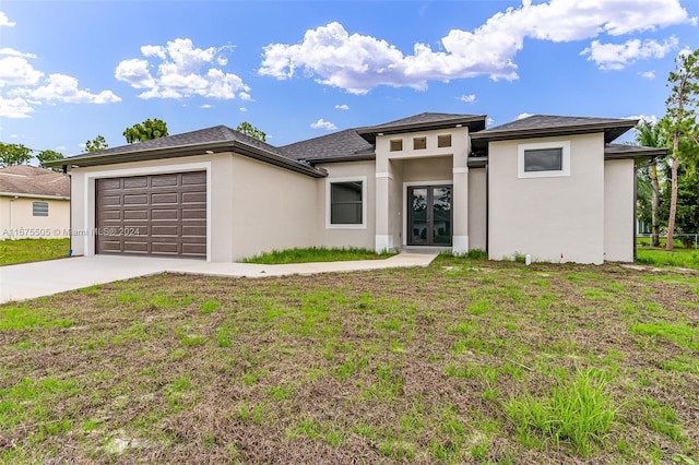 prairie-style home with a front yard and a garage