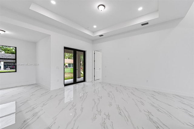 unfurnished room featuring a raised ceiling