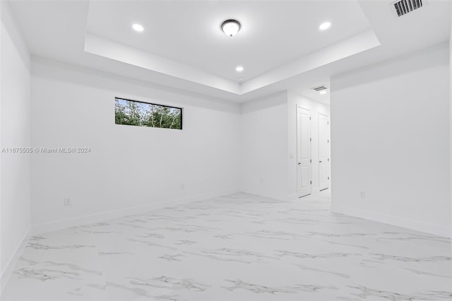 unfurnished room with a tray ceiling