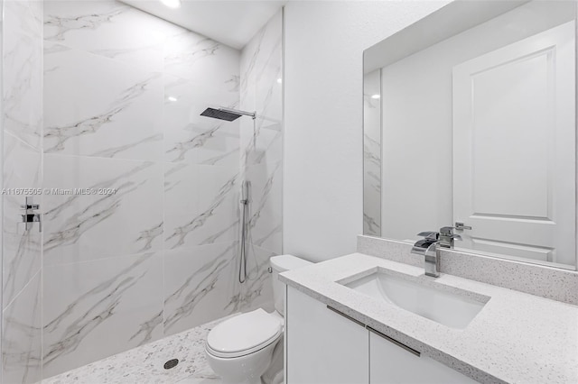 bathroom featuring vanity, toilet, and tiled shower