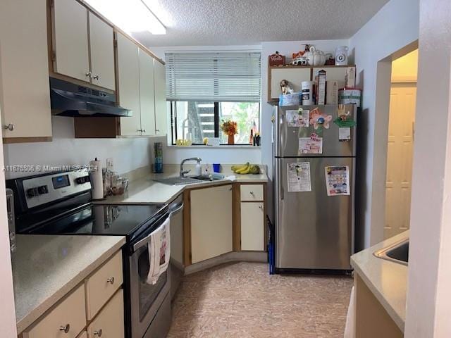 kitchen featuring stainless steel appliances, sink, and a textured ceiling