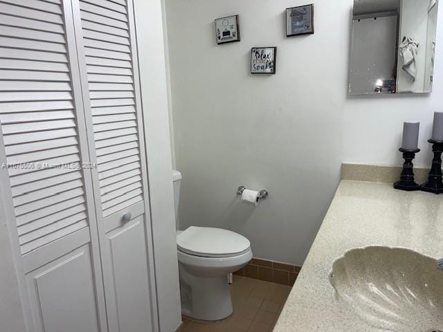 bathroom featuring vanity, tile patterned flooring, and toilet