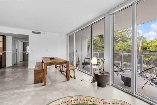 interior space with a wall of windows and concrete flooring