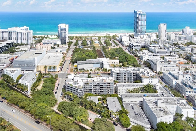 birds eye view of property with a water view and a beach view