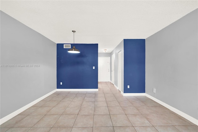 tiled spare room with a textured ceiling