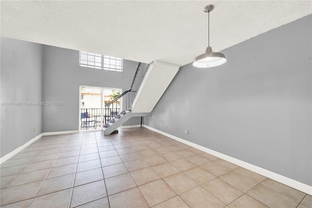 unfurnished living room with light tile patterned floors and a textured ceiling