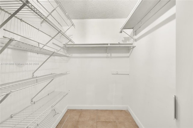 walk in closet with light tile patterned floors