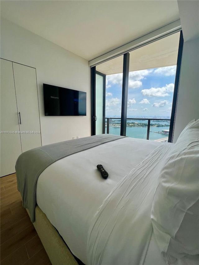 bedroom featuring dark hardwood / wood-style floors, access to exterior, and floor to ceiling windows