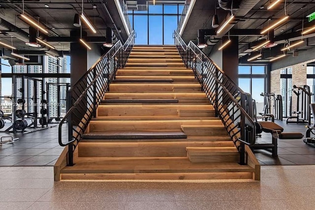 stairs with a wall of windows and a towering ceiling