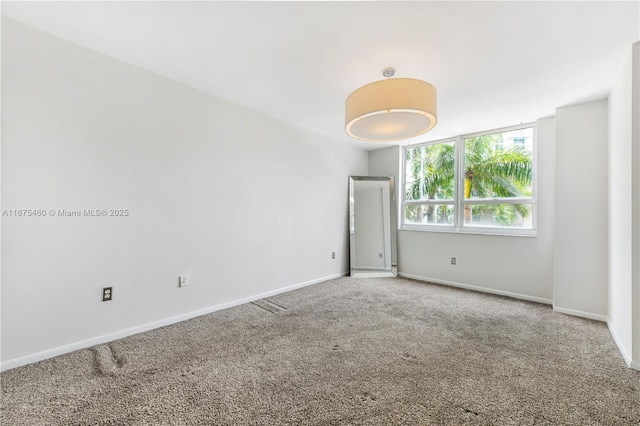 carpeted empty room with baseboards