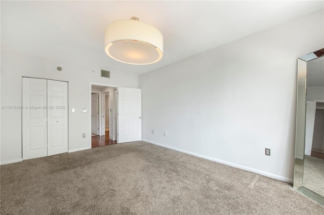 unfurnished bedroom featuring carpet floors, a closet, visible vents, and baseboards