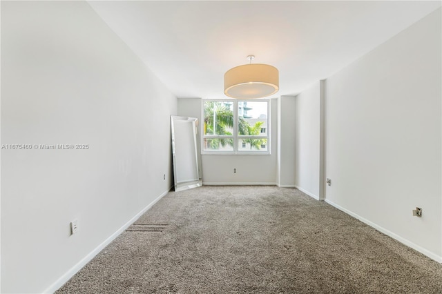 spare room with light colored carpet and baseboards