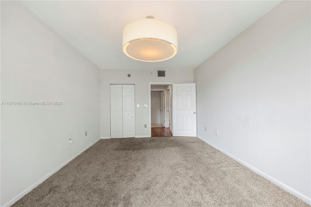 unfurnished bedroom with carpet, a closet, visible vents, and baseboards