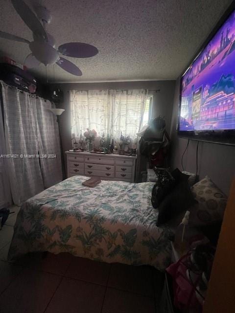 bedroom featuring ceiling fan, a textured ceiling, and tile patterned flooring