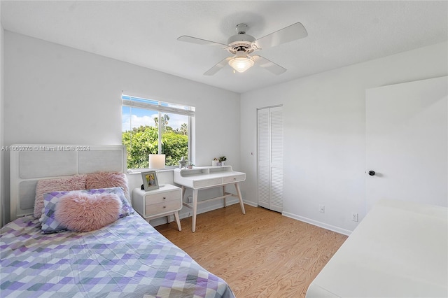 bedroom with light wood-type flooring, ceiling fan, and a closet