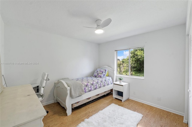 bedroom featuring a textured ceiling, light wood-type flooring, and ceiling fan