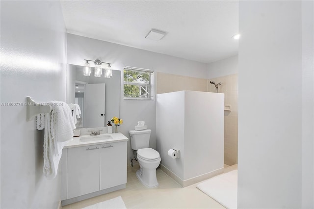 bathroom featuring tile patterned floors, a tile shower, toilet, and vanity