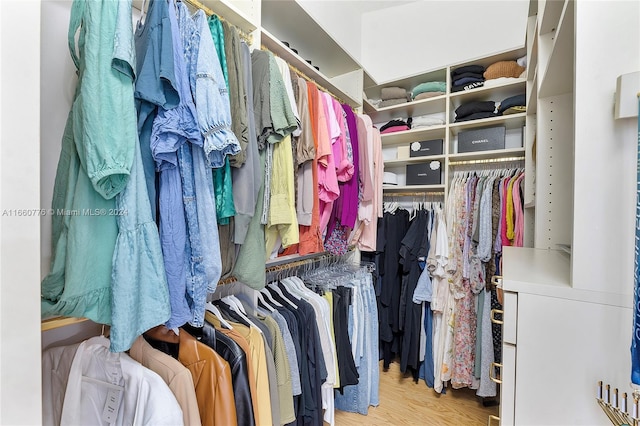 walk in closet with light hardwood / wood-style flooring