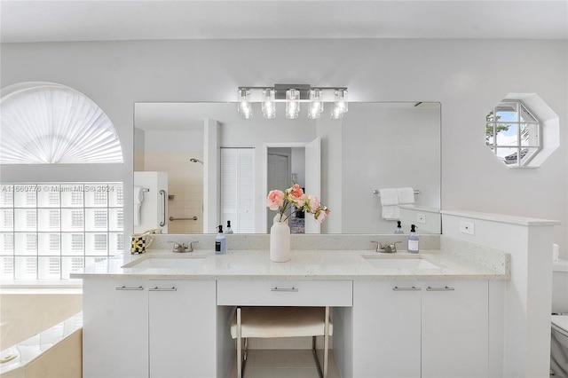 bathroom with tile patterned floors, a tile shower, toilet, and vanity