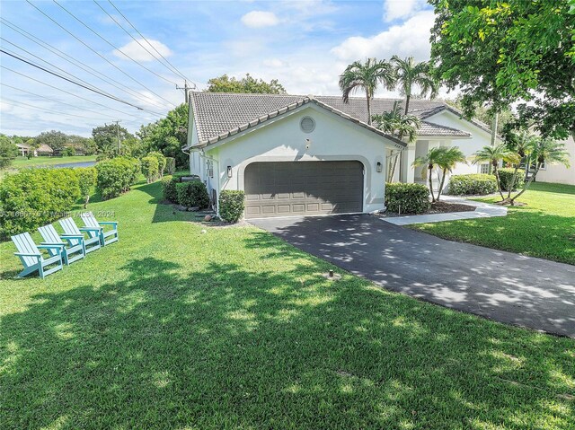 view of front of house with a front yard and a garage