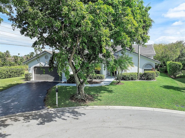 obstructed view of property featuring a front yard and a garage