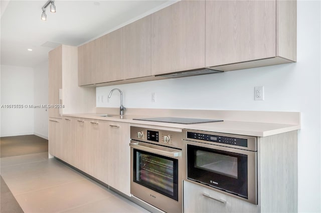 kitchen featuring oven and light brown cabinets