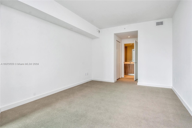 spare room featuring baseboards, visible vents, and carpet floors
