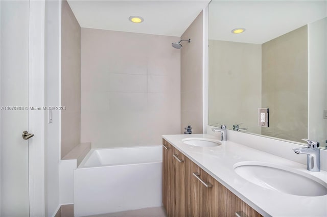 full bath with a sink, a tub to relax in, and double vanity