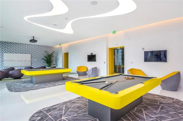 game room with an accent wall and billiards