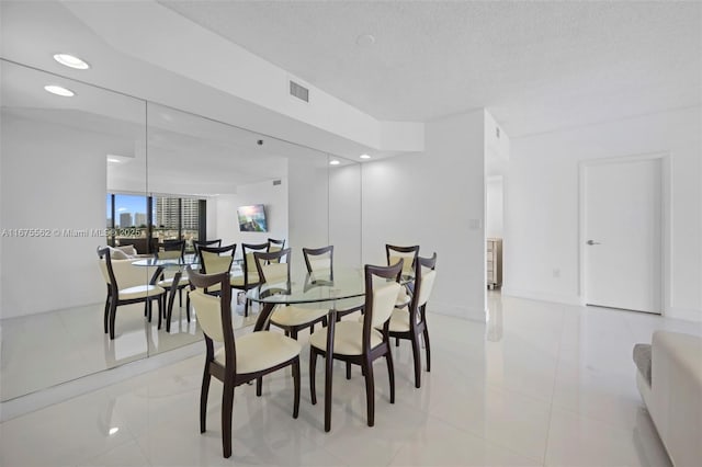 dining area featuring light tile patterned floors and a textured ceiling