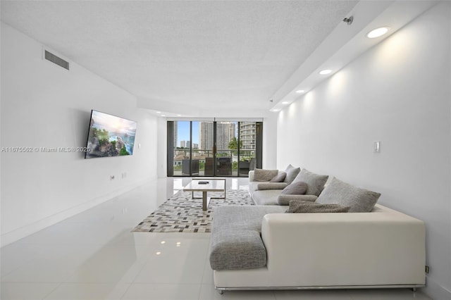 tiled living room featuring expansive windows and a textured ceiling