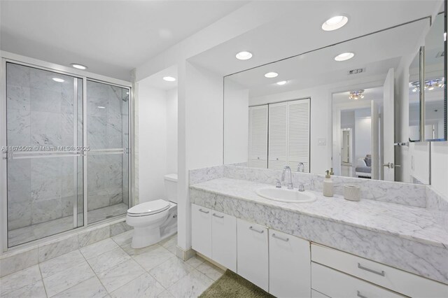 bathroom featuring vanity, toilet, and a shower with shower door