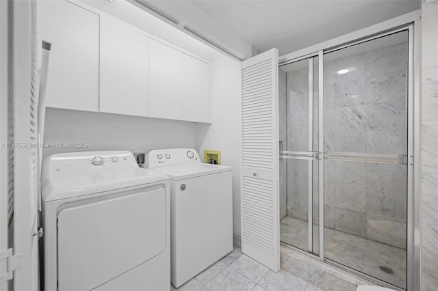 clothes washing area featuring cabinets and separate washer and dryer