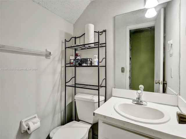 bathroom featuring vanity, a textured ceiling, and toilet