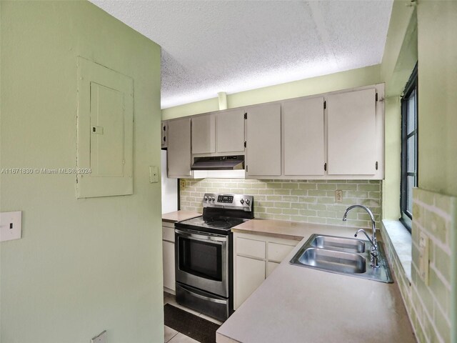 kitchen featuring decorative backsplash, electric panel, sink, and stainless steel electric range