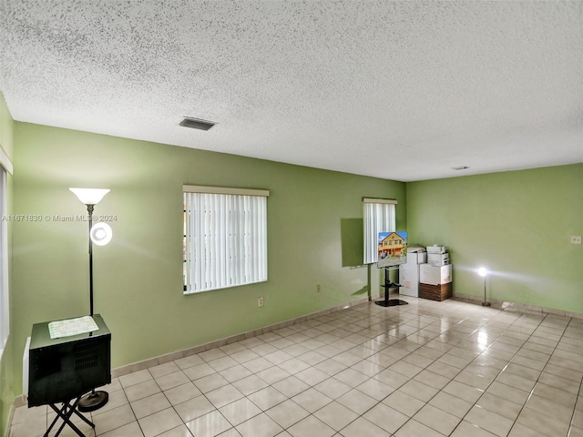 interior space with a textured ceiling and light tile patterned floors