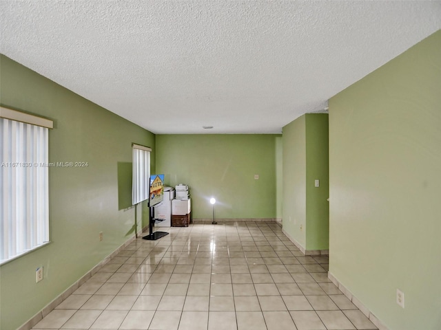 empty room featuring light tile patterned floors and a textured ceiling