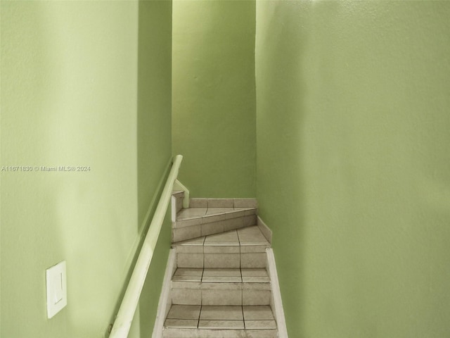 stairway with tile patterned floors