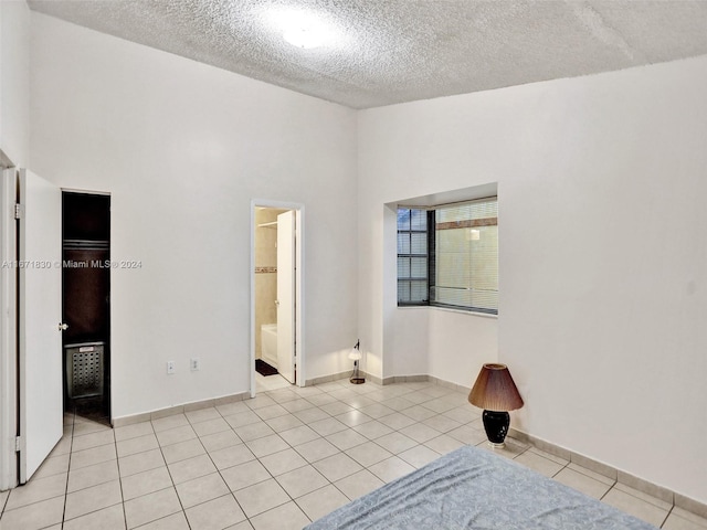 empty room with light tile patterned flooring and a textured ceiling