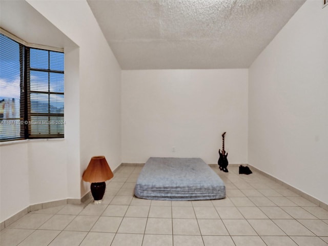 living area with light tile patterned floors and a textured ceiling