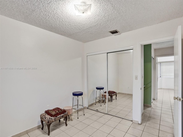 living area featuring light tile patterned flooring and a textured ceiling