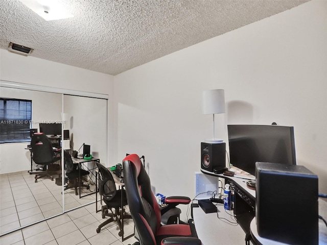 home office with light tile patterned flooring and a textured ceiling