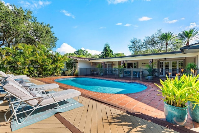 view of swimming pool with french doors, a patio area, and a wooden deck